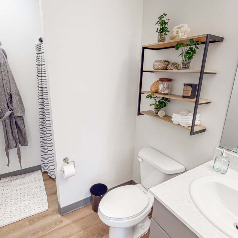 Apartment bathroom with vanity, mirror, & shower