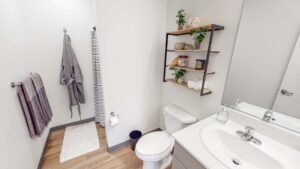 Apartment bathroom with vanity, mirror, & shower